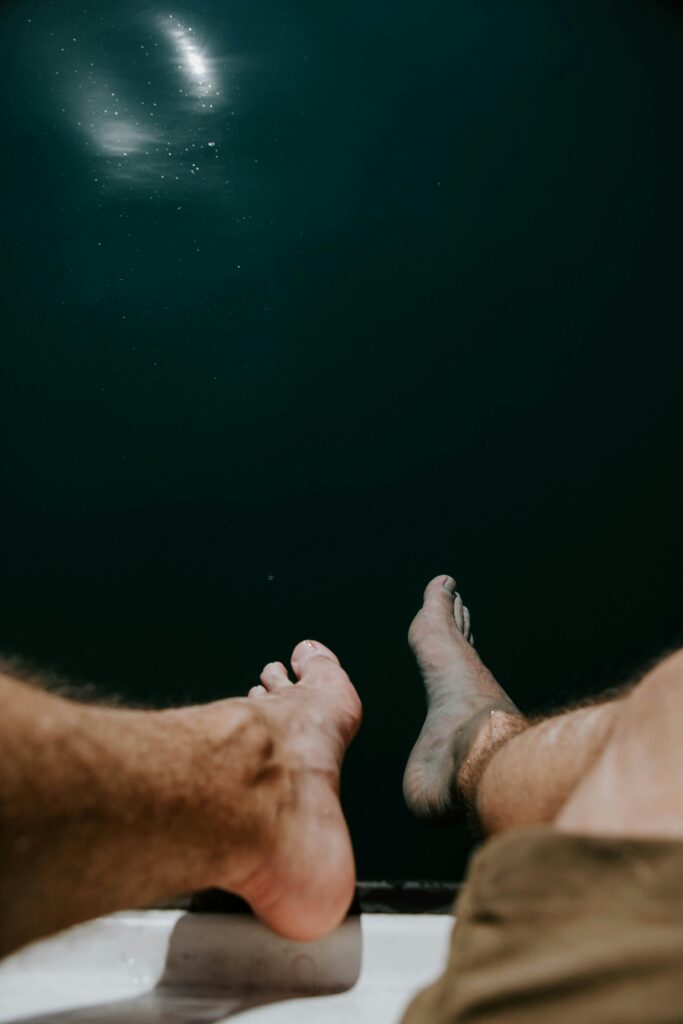 Bare feet dangling above tranquil waters in Schwangau, Germany, conveying relaxation and serenity.